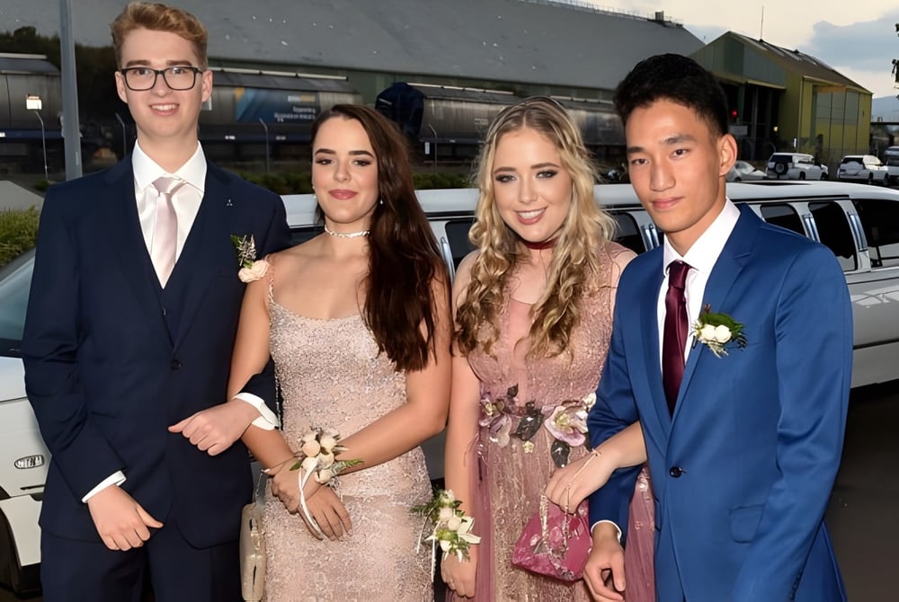 Vier gepflegt gekleidete Personen stehen vor einem Fahrzeug auf dem Gelände der Cathedral School of St Anne & St James.