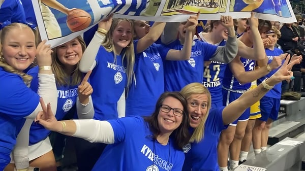 Schülerinnen der Catholic Central High School jubeln und feiern im Sportbereich mit Bannern im Hintergrund.