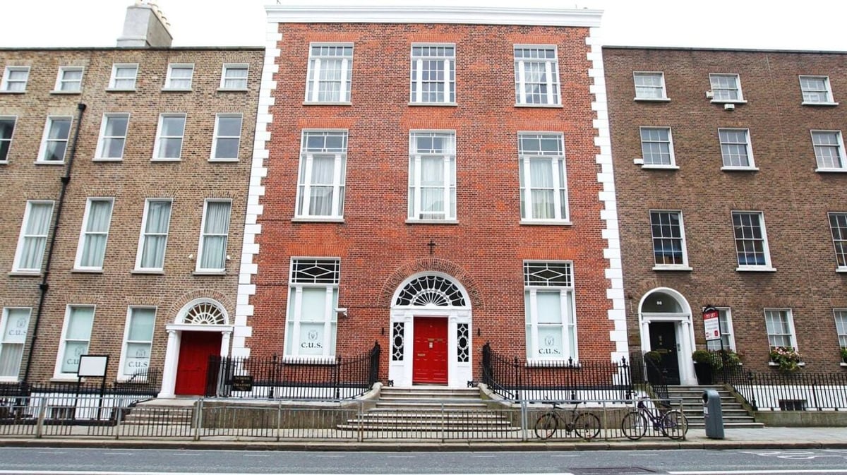 Das Backsteingebäude mit Bögen und roten Türen gehört zur Catholic University School.