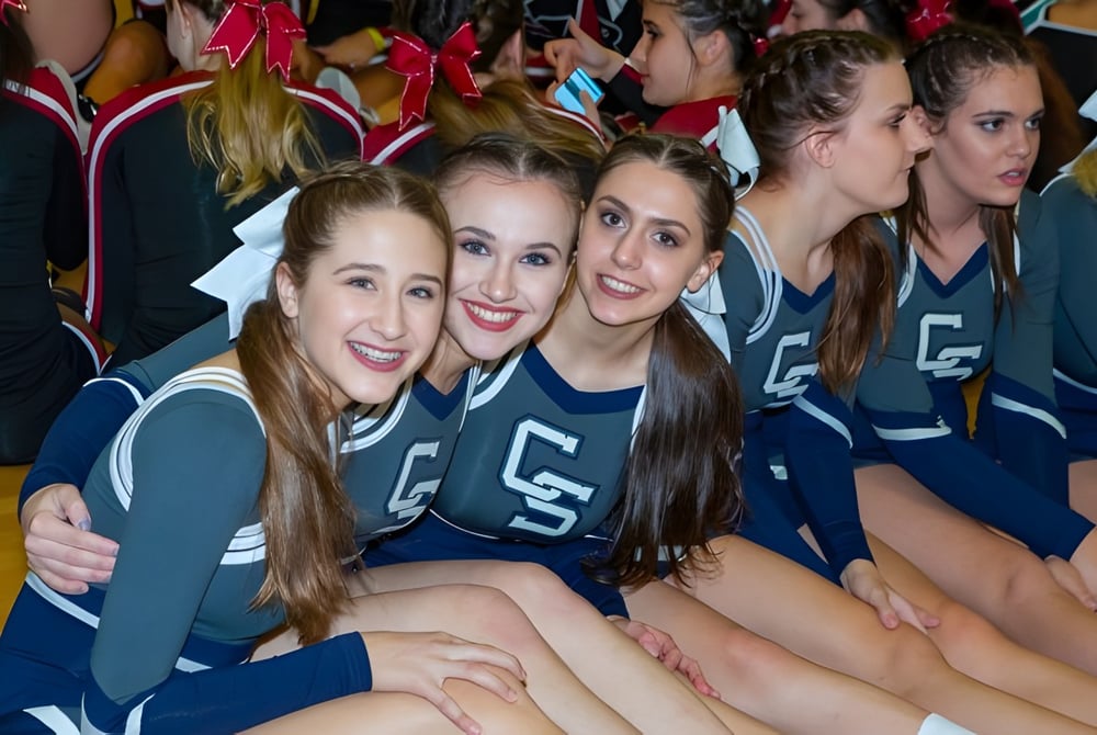 Eine Gruppe junger Cheerleaderinnen posiert im Cave Creek Unified School District in ihren einheitlichen Uniformen in der Sporthalle.