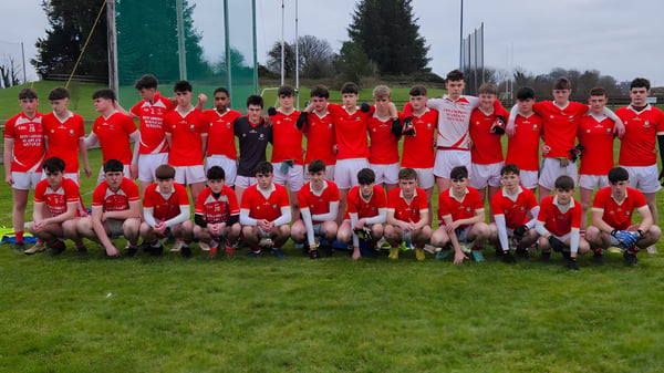 Eine große Gruppe von jungen Fußballspielern in roten Trikots steht auf dem Sportfeld der C.B.S. Roscommon.