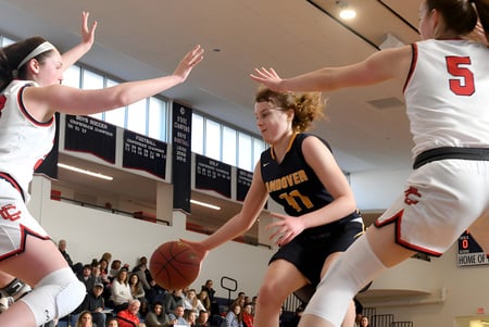 Schüler des Centennial Collegiate Vocational Institute spielen ein Basketballspiel auf dem Spielfeld vor Zuschauern.
