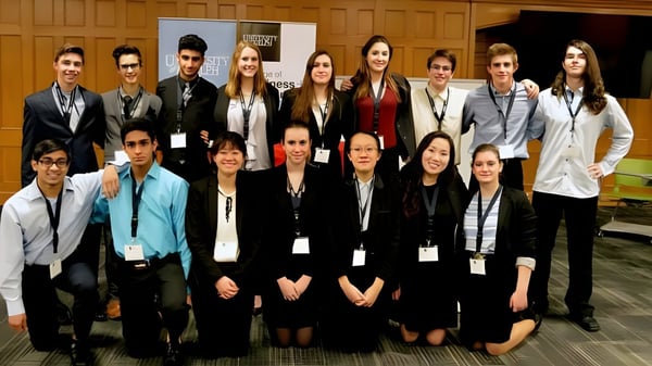 Eine Gruppe junger Erwachsener in formaler Kleidung posiert in einem Konferenzraum auf dem Campus des Centennial Collegiate Vocational Institute.