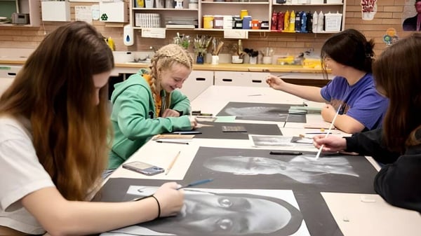 Schülerinnen arbeiten gemeinsam an einem Tisch im Kunststudio der Centennial Collegiate.