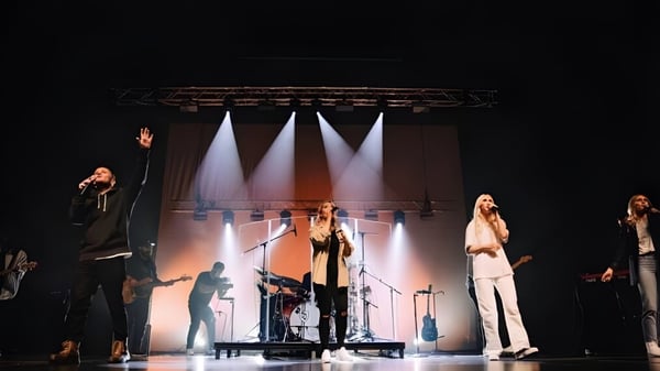 Eine Gruppe von Schülern der Centennial Secondary School tritt auf der hell beleuchteten Bühne auf.