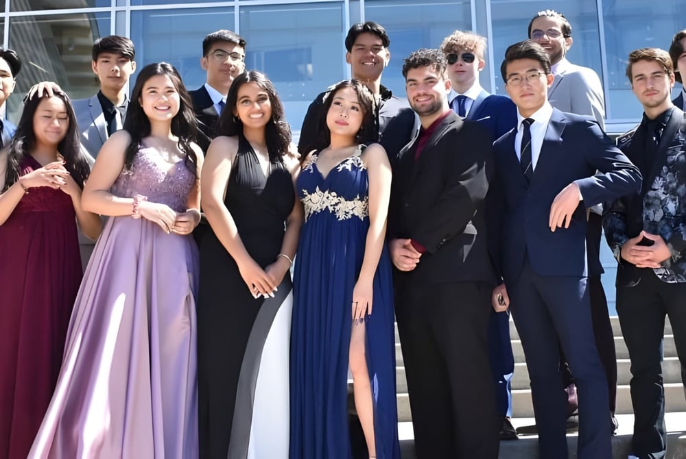 Schüler der Centennial Secondary School in formeller Kleidung vor einem Glasgebäude posierend.