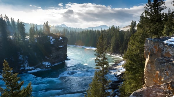 Eine beeindruckende Landschaft mit einem rauschenden Fluss und schneebedeckten Bergen nahe der Centennial Secondary School in Ontario.