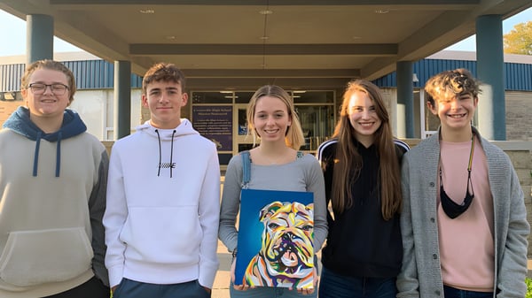 Eine Gruppe von fünf Schülerinnen und Schülern steht gemeinsam vor einem Gebäude auf dem Campus der Centerville Senior High School.