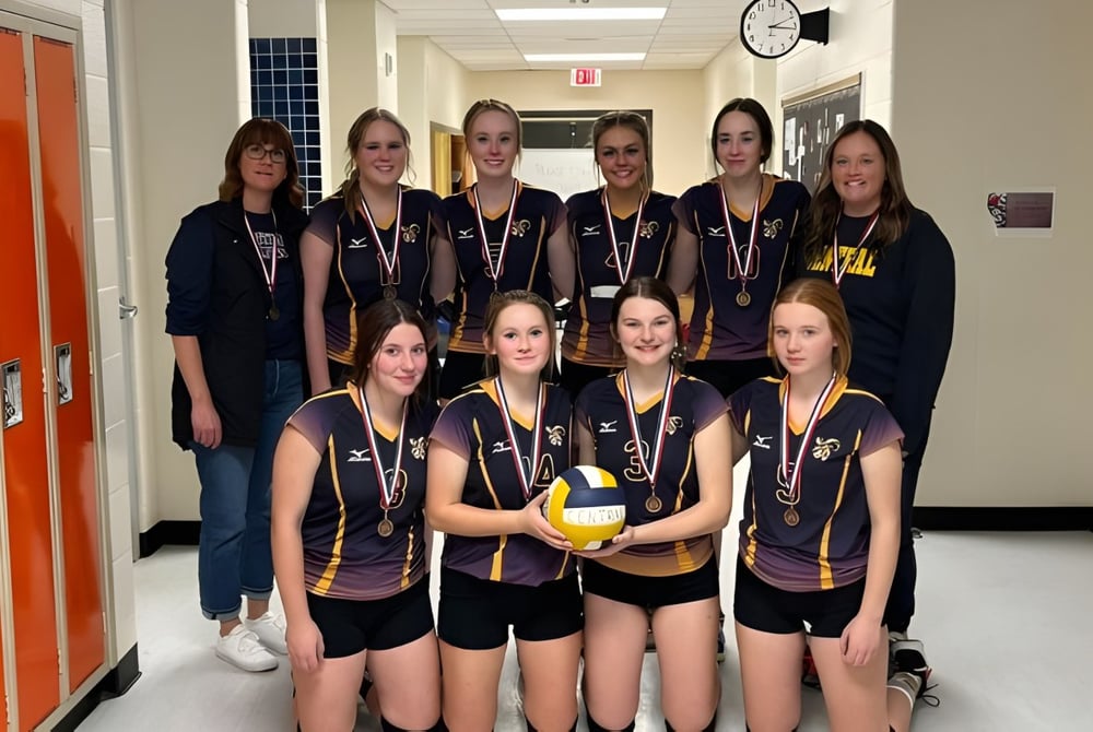 Eine Gruppe weiblicher Volleyballspielerinnen steht im Flur der Central High Sedgewick Public School in ihren Schuluniformen.