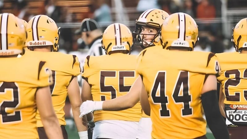 Eine Gruppe von Footballspielern der Central Regional High School steht in gelben Uniformen auf dem Spielfeld.