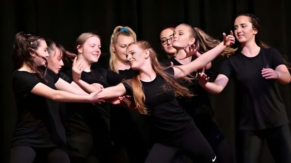 Eine Gruppe junger Frauen in schwarzer Kleidung führt eine Aufführung auf der Bühne des Central Southland College durch.