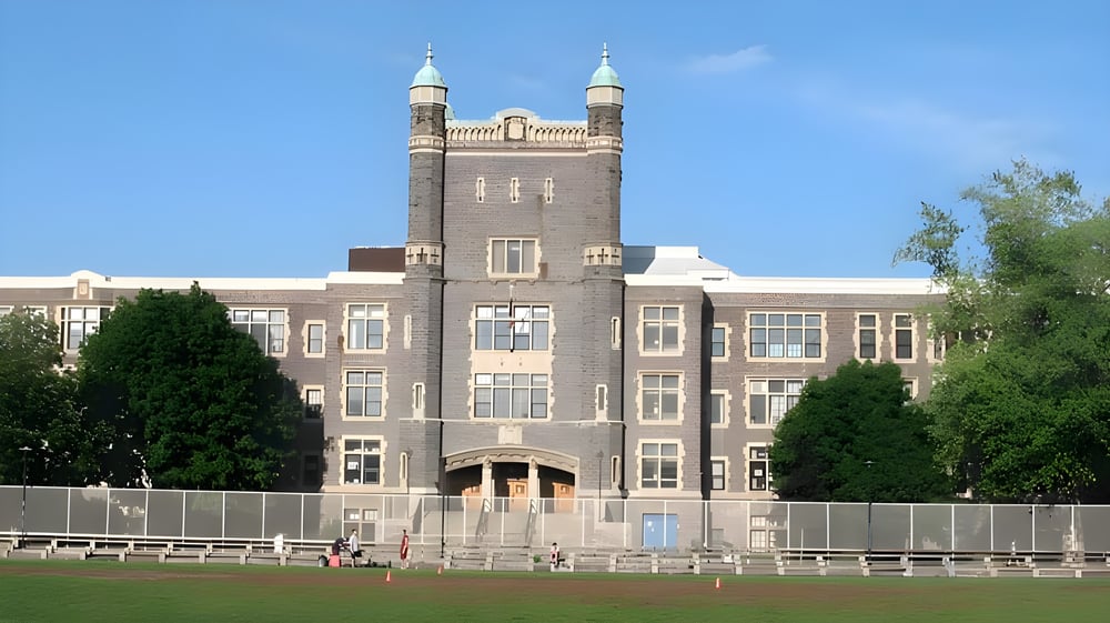 Das Gebäude der Central Technical School mit zwei Türmen und umgeben von grüner Vegetation ist sichtbar.