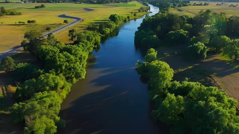 Ein ruhiger Fluss fließt durch eine grüne Landschaft in der Nähe der Central Yorke School.