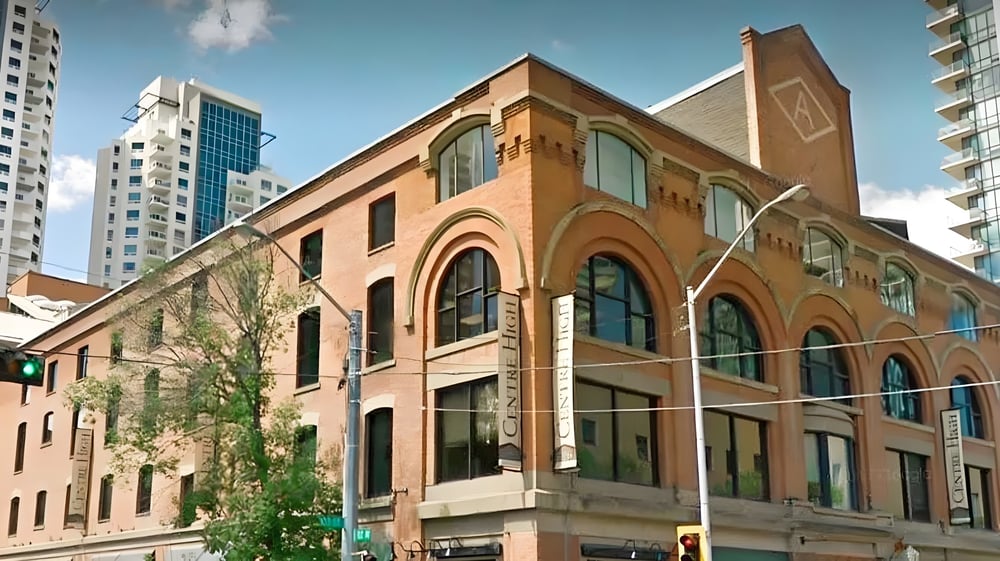 Das historische Backsteingebäude auf dem Campus der Centre High Campus steht vor modernen Hochhäusern.