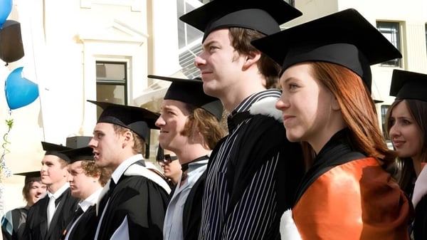 Eine Gruppe von Absolventinnen und Absolventen in Talaren feiert ihren Abschluss an der Centre Wellington District High School.