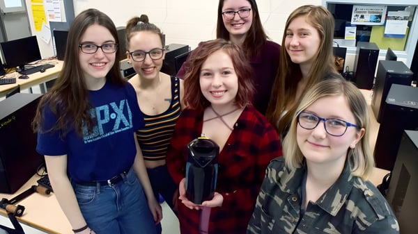 Eine Gruppe von Schülerinnen der Centre Wellington District High School lächelt gemeinsam in einem Klassenzimmer.