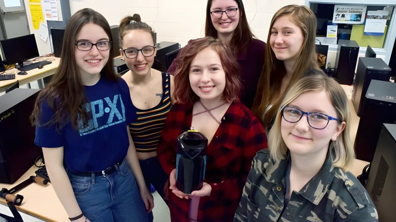 Eine Gruppe von Schülerinnen der Centre Wellington District High School lächelt gemeinsam in einem Klassenzimmer.