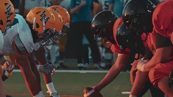 Eine Gruppe von Fußballspielern steht in orange-schwarzen Uniformen auf dem Spielfeld der Chaffey High School.