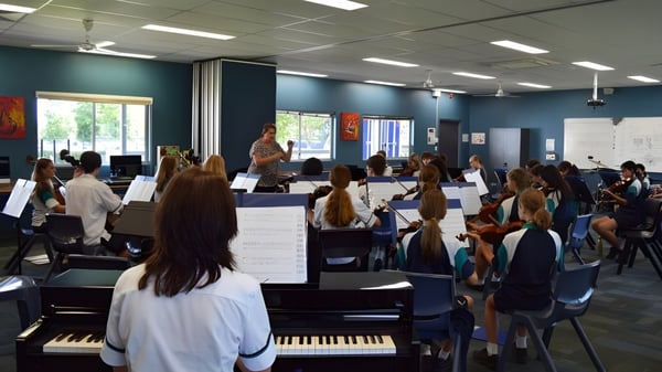 Schülerinnen und Schüler spielen verschiedene Musikinstrumente im Musikunterricht am Chancellor State College.