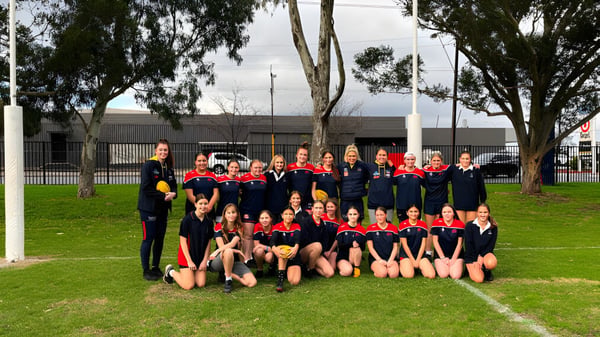Eine Gruppe junger Athletinnen posiert auf einem Rasenfeld auf dem Campus des Charles Campbell College.