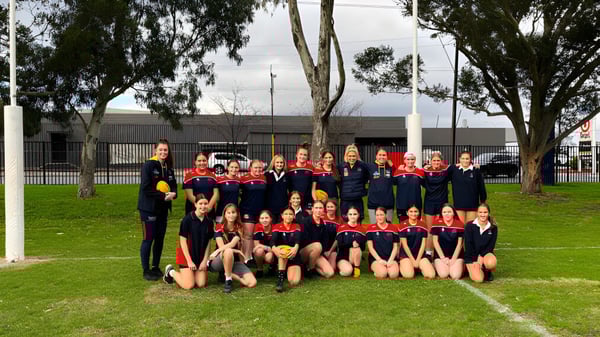 Eine Gruppe junger Athletinnen posiert auf einem Rasenfeld auf dem Campus des Charles Campbell College.