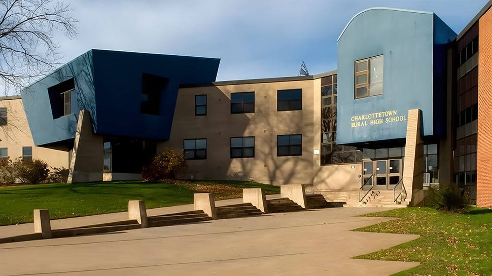 Das moderne Gebäude der Charlottetown Rural High School steht in einer Grünfläche mit Gehwegen zum Eingang.