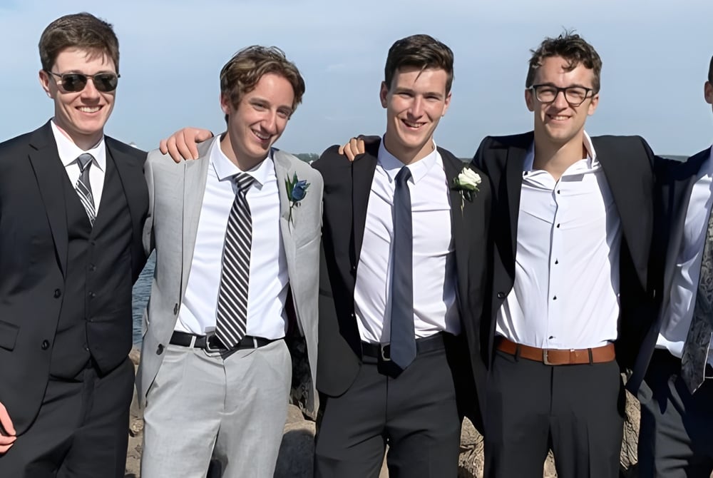 Fünf Schüler der Charlottetown Rural High School stehen zusammen in formeller Kleidung vor einem Gewässer.