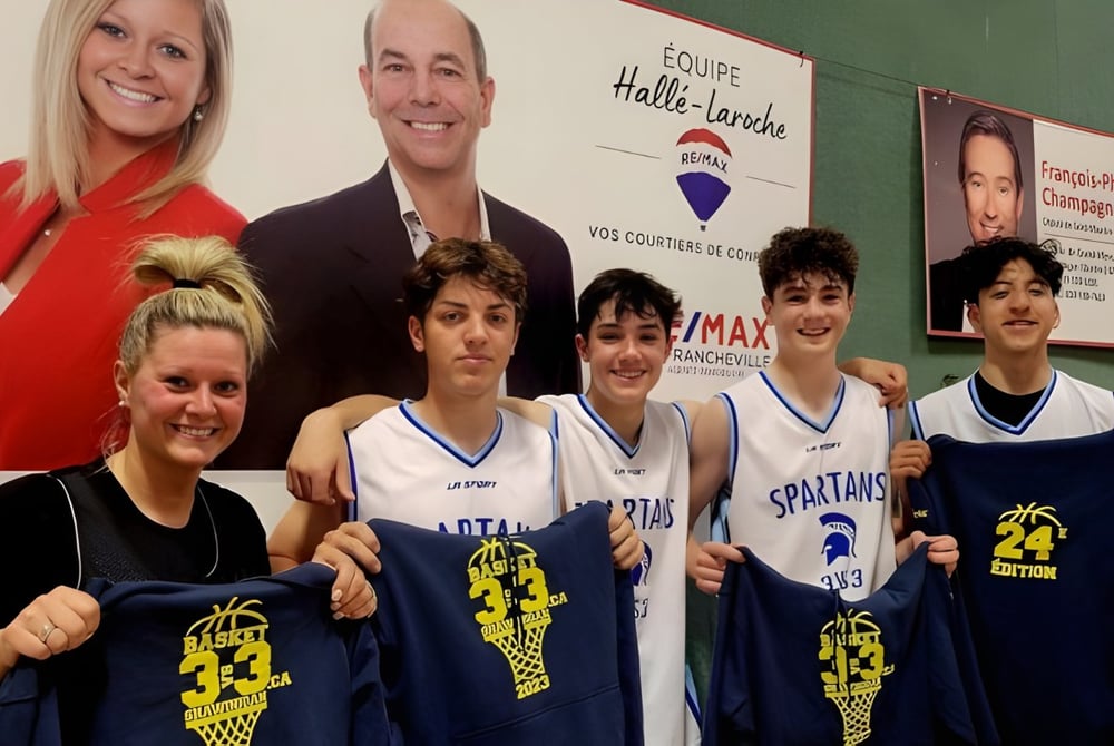 Eine Gruppe junger Basketballspieler posiert vor einem Banner mit politischen Kandidaten auf dem Campus der Chateauguay Valley Regional High School.