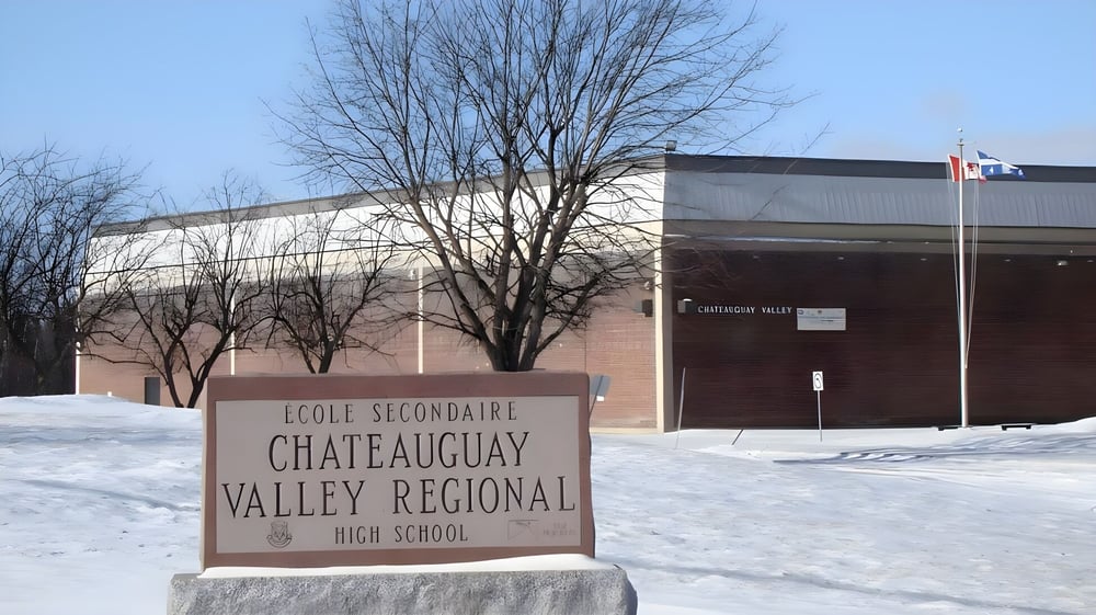 Das schneebedeckte Schul-Schild steht vor dem Backsteingebäude der Chateauguay Valley Regional High School.