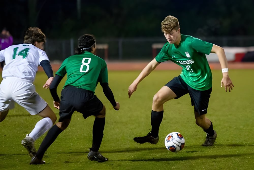 Schüler der Chatelech Secondary School spielen ein Fußballspiel auf dem Sportplatz bei Nacht.