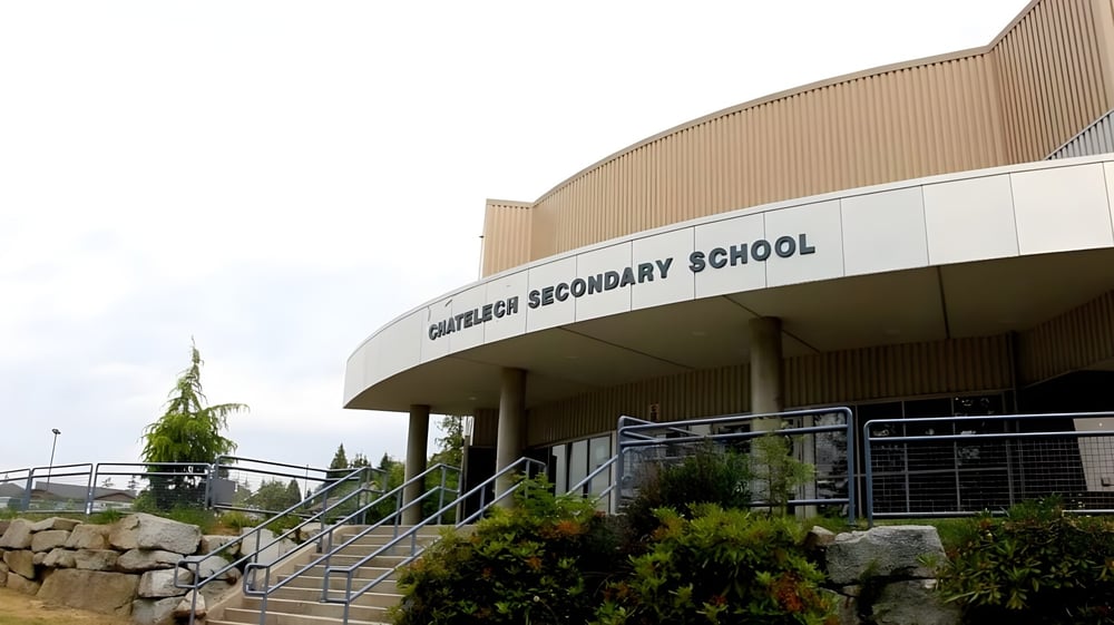 Das moderne Gebäude der Chatelech Secondary School mit geschwungenem Dach und markantem Eingang vor begrüntem Gelände.