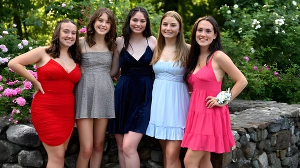 Eine Gruppe von fünf Schülerinnen steht zusammen in einem blühenden Garten auf dem Campus der Chatham Hall School.