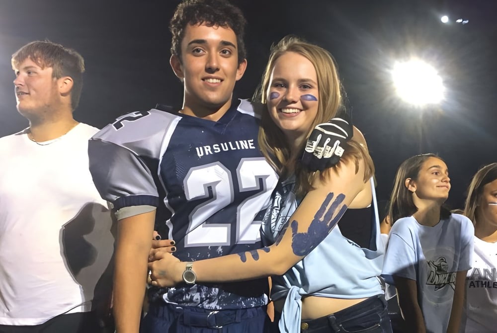 Eine Gruppe Schülerinnen und Schüler der Chatham Kent Secondary School steht nachts zusammen und lächelt.