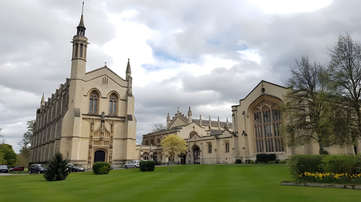 Eine prächtige gotische Kathedrale mit hohem Turm steht im grünen Innenhof des Cheltenham College unter bewölktem Himmel.
