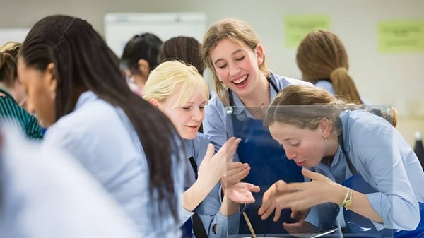 Eine Gruppe Schülerinnen des Cheltenham Ladies' College unterhält sich lebhaft in einem Klassenraum.