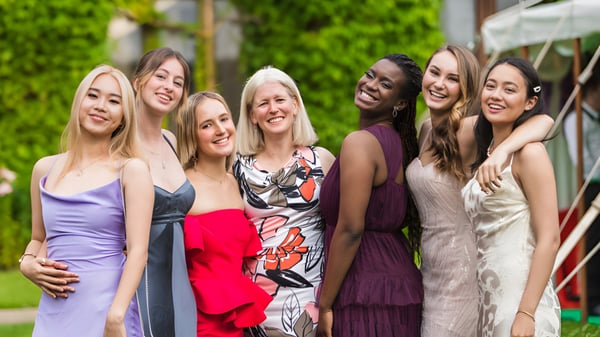 Eine Gruppe stilvoll gekleideter Schülerinnen posiert im grünen Außenbereich des Cheltenham Ladies' College.
