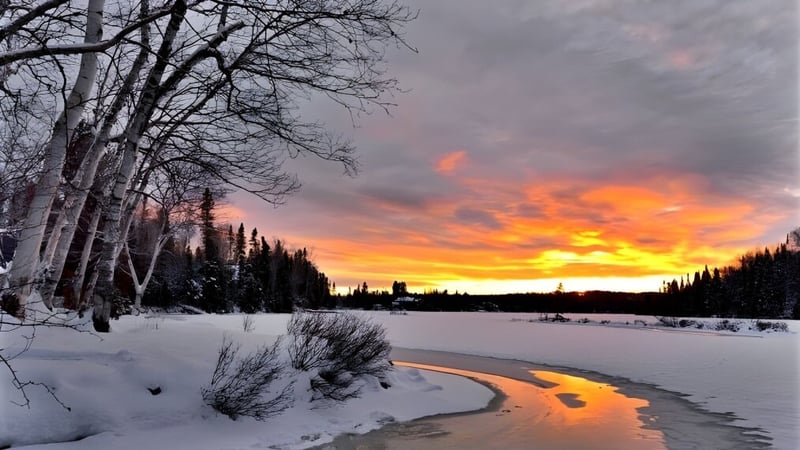 Ein schneebedecktes Landschaftsbild mit einem gewundenen Bach und Feuerhimmel auf dem Campus der Chemainus Secondary School.
