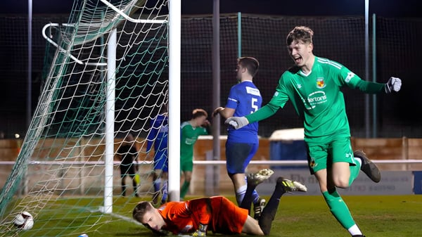 Ein Torwart in grünem Trikot macht eine Parade beim Fußballspiel auf dem Sportplatz von Cheshire College South & West.