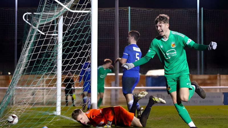 Ein Torwart in grünem Trikot macht eine Parade beim Fußballspiel auf dem Sportplatz von Cheshire College South & West.