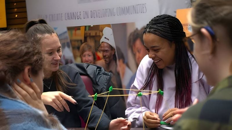 Eine Gruppe Studierender am Chichester College arbeitet gemeinsam mit Faden in einer Gruppenaktivität.