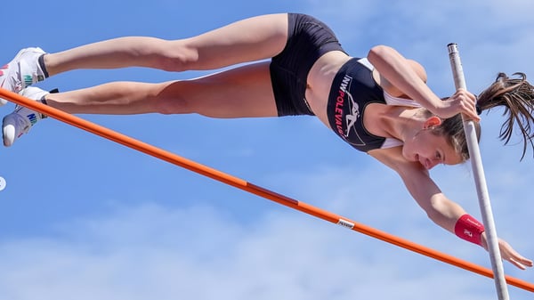 Eine Schülerin der Chief Sealth High School führt beim Sport den Hochsprung über die orange Stange aus.