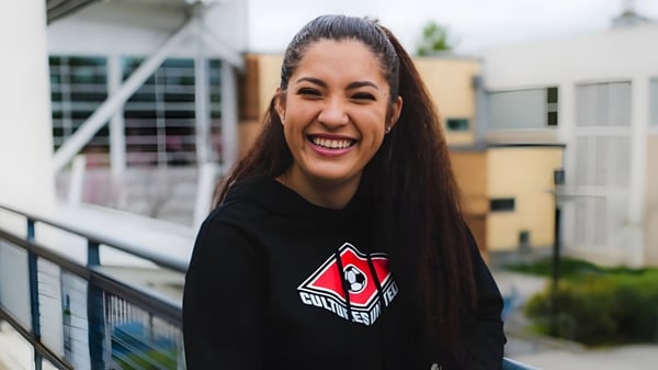 Eine Schülerin der Chief Sealth High School steht vor einem Gebäude mit einem bunten Wandbild.