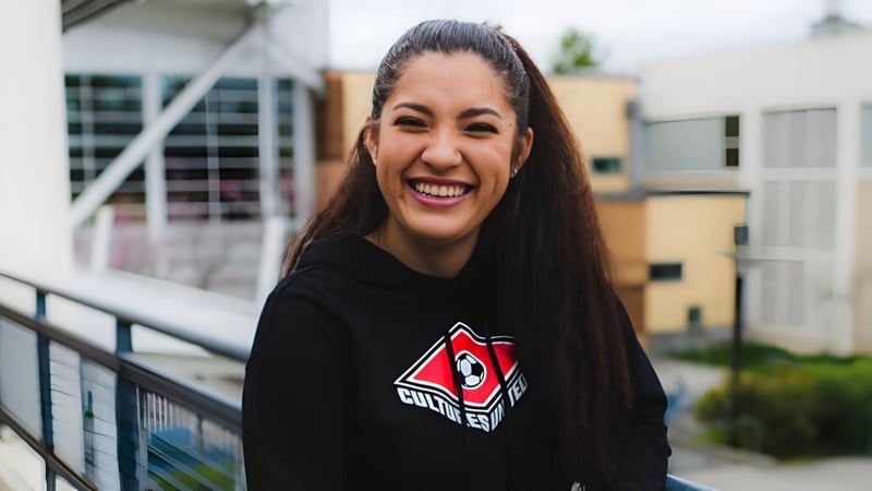 Eine Schülerin der Chief Sealth High School steht vor einem Gebäude mit einem bunten Wandbild.