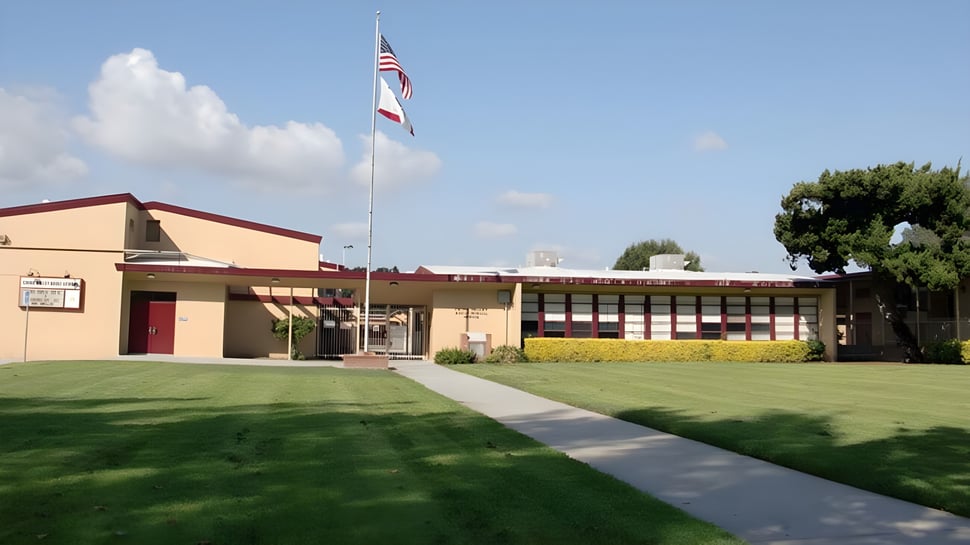 Ein eingeschossiges Gebäude mit rotem Dach und amerikanischer Flagge auf dem Gelände des Chino Valley Unified School District.