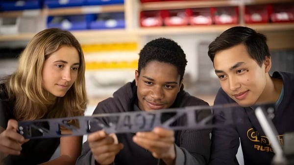 Drei Schüler der Choate Rosemary Hall betrachten gemeinsam ein Dokument in einem Klassenraum.