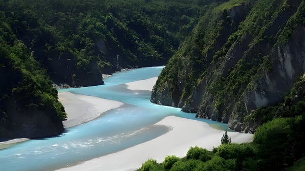 Ein türkisfarbener Fluss windet sich durch eine bewaldete Schlucht mit moosbedeckten Felsen in der Nähe der Christchurch Boys High School.