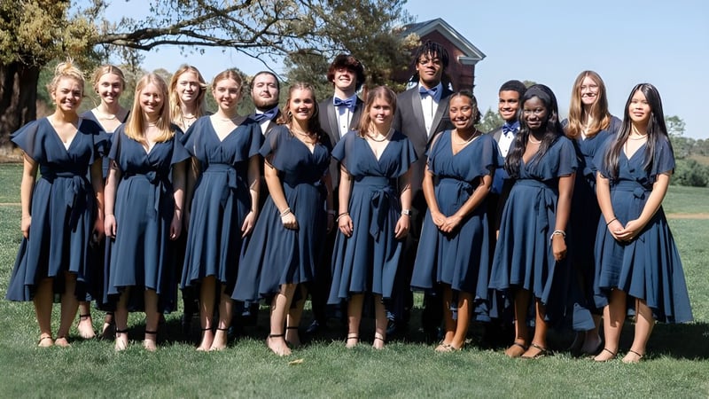 Schüler der Christchurch School stehen im Freien auf einer Wiese und treten als Chor auf.