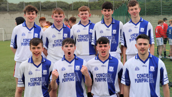 Eine Gruppe junger Fußballspieler in blauen und weißen Trikots posiert für ein Teamfoto auf dem Sportplatz der Christian Brothers School Kilkenny.