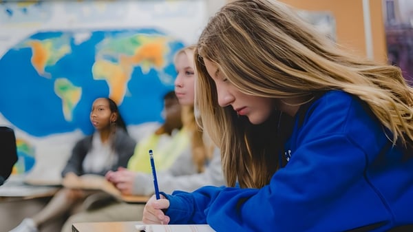 Eine Schülerin der Christian Life School arbeitet konzentriert vor einer farbigen Weltkarte.