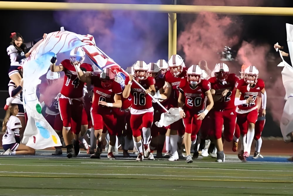 Eine Gruppe von Football-Spielern in roten Uniformen steht auf dem Spielfeld während einer Veranstaltung an den Christian Unified Schools.